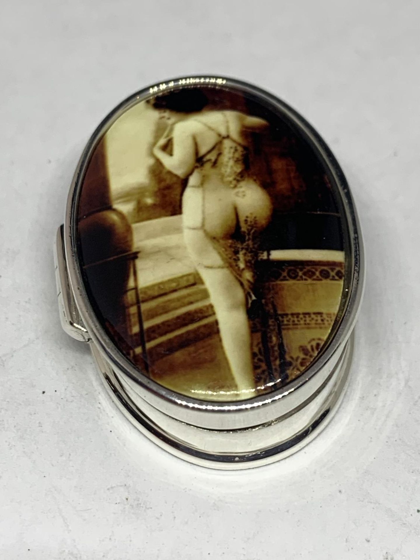 A MARKED 925 SILVER PILL BOX WITH AN ENAMEL EROTIC DESIGN TOP