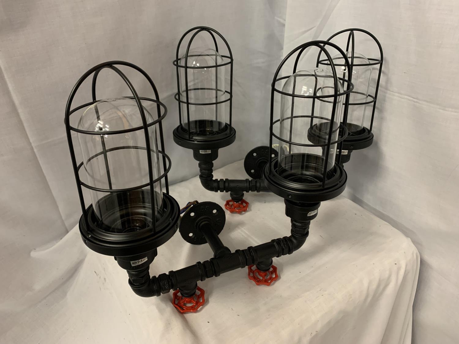 A PAIR OF INDUSTRIAL STYLE TWIN WALL LIGHTS WITH CAGED SHADES AND STEAM PIPE WITH TAPS EFFECT