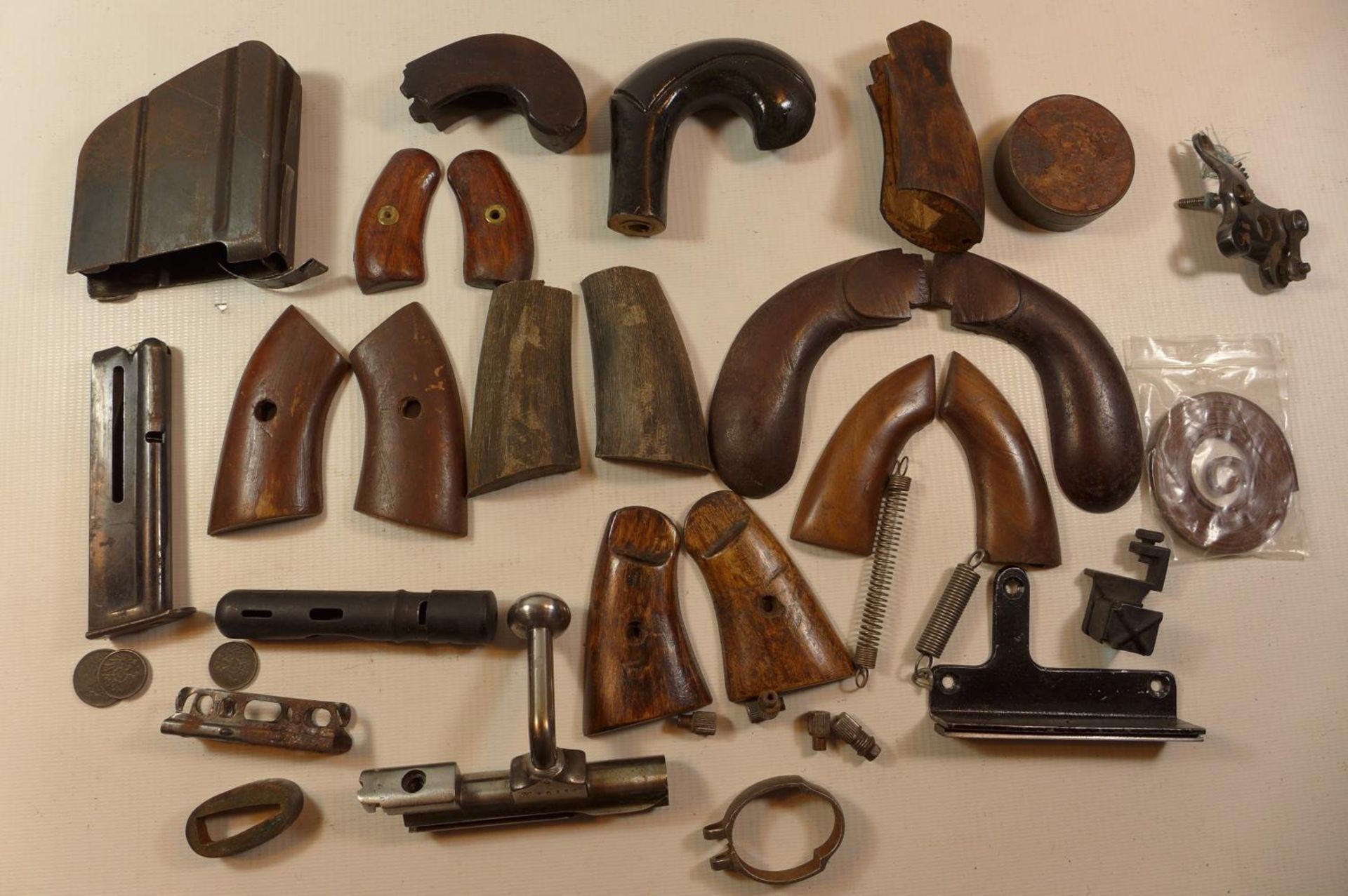 A COLLECTION OF GUN PARTS, TO INCLUDE SETS OF WOODEN GRIPS, MAGAZINES,SPRINGS ETC