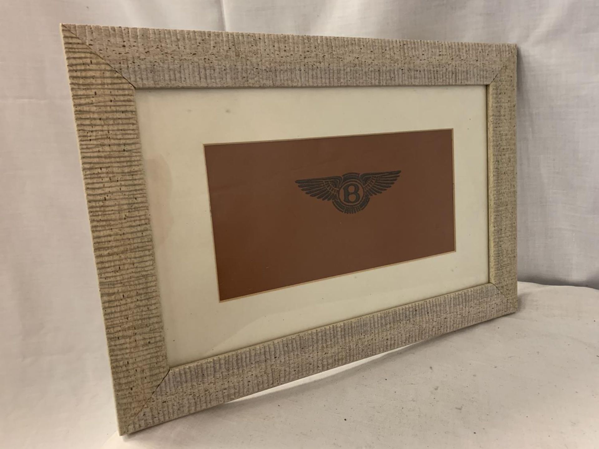 A FRAMED TAN LEATHER WITH EMBROIDERED BENTLEY LOGO