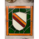 A STAINED GLASS PANEL DEPICTING A SHIELD 34CM X 30CM