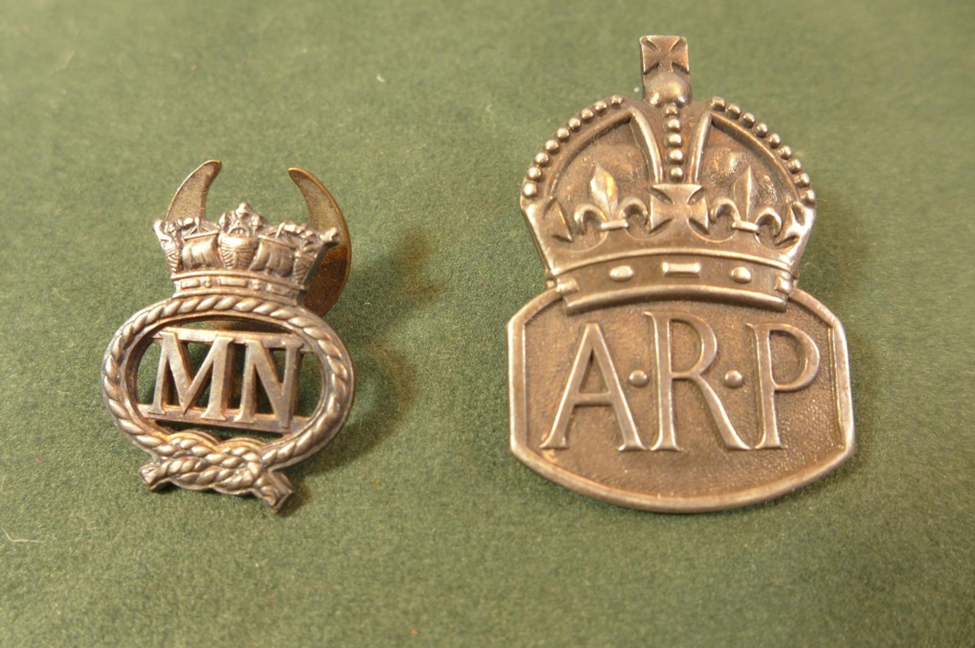 A HALLMARKED SILVER ARP BADGE AND A MERCHANT NAVY ON SERVICE BADGE