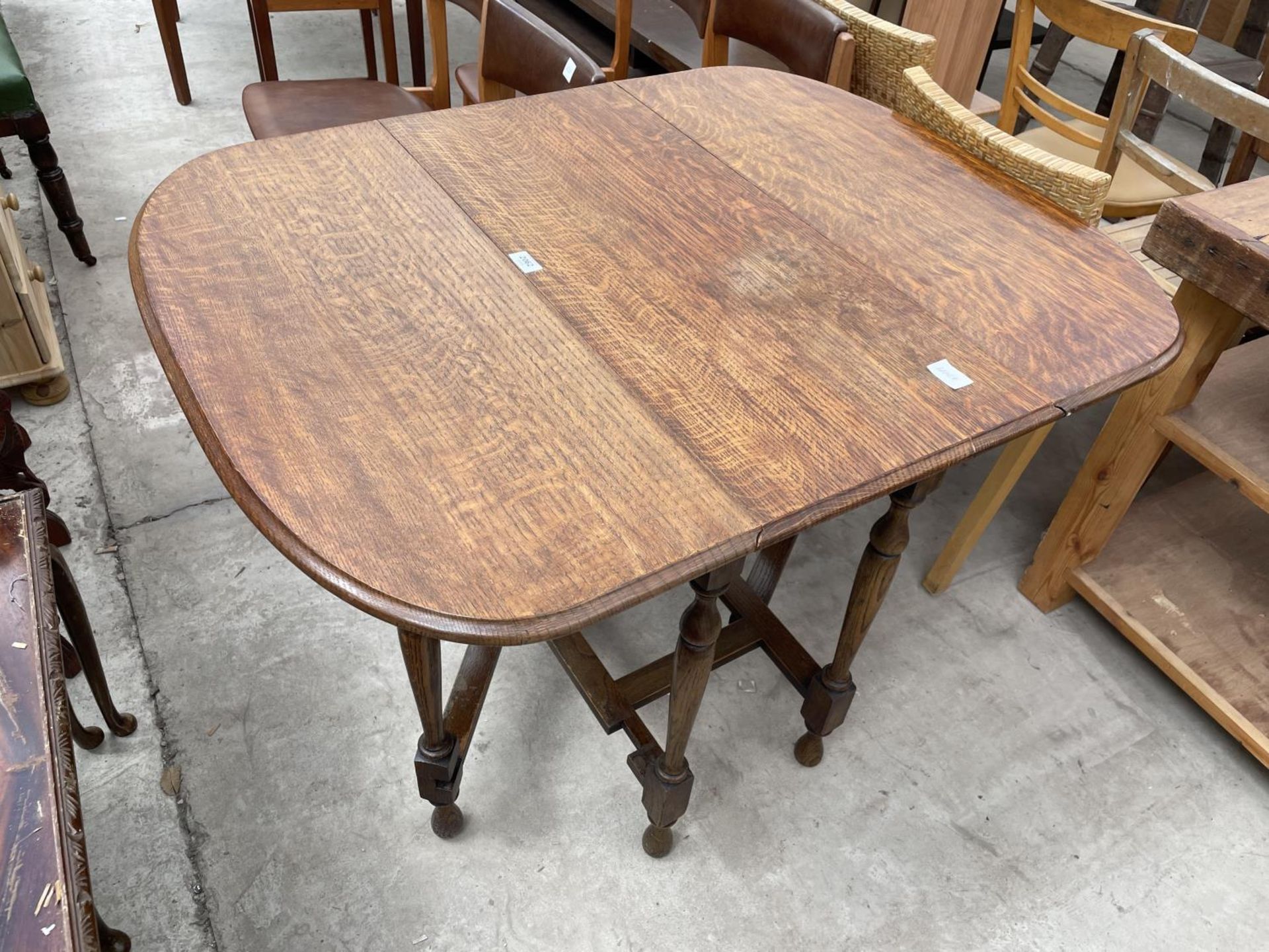 AN EARLY 20TH CENTURY OAK GATELEG TABLE ON TURNED LEGS