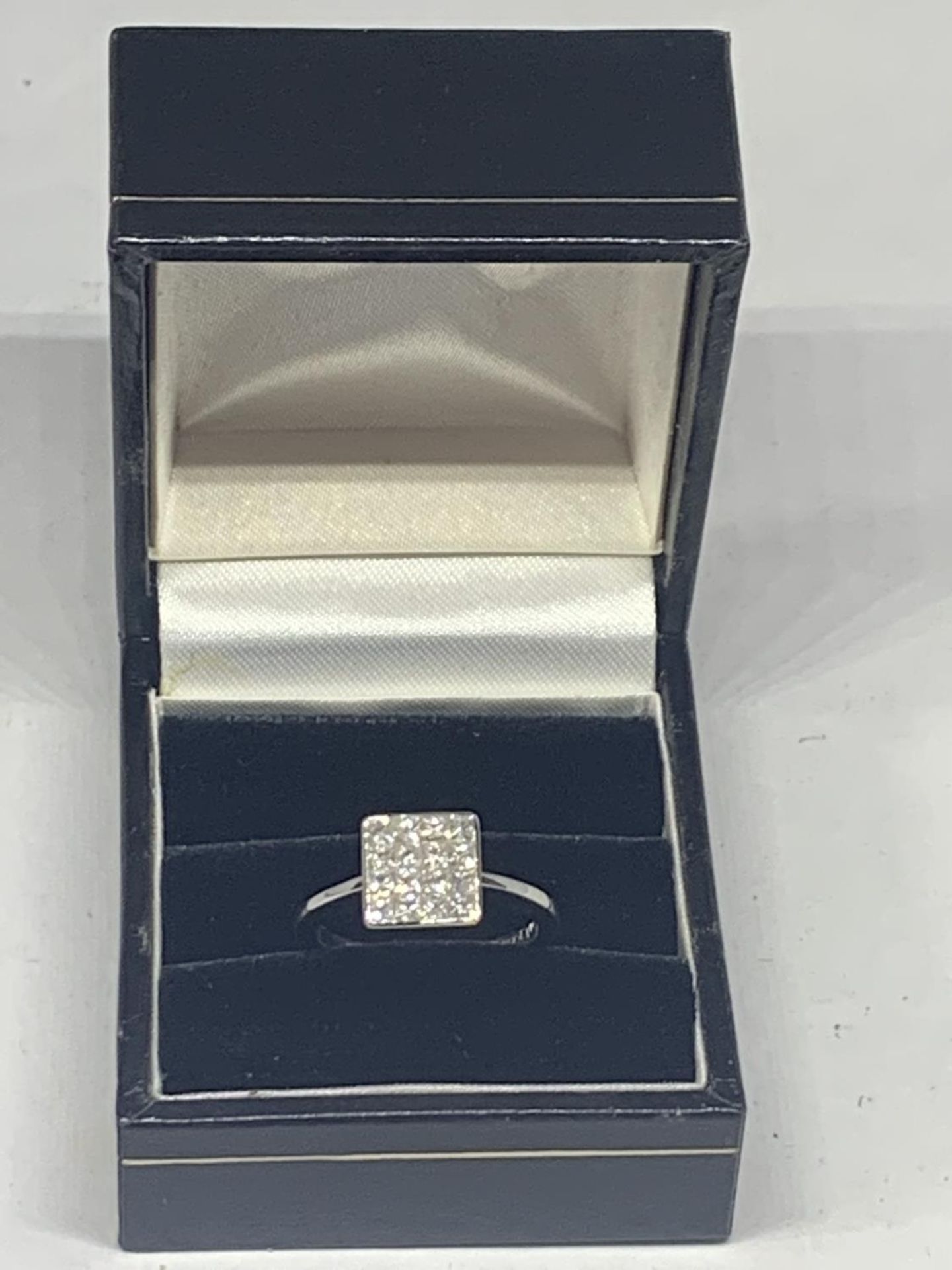 AN 18 CARAT WHITE GOLD RING WITH SIXTEEN DIAMONDS SET IN A SQUARE GROSS WIEGHT 3.9 GRAMS SIZE L/M