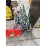 AN ASSORTMENT OF GARDEN TOOLS TO INCLUDE SHEARS, RAKES AND A SNOW SHOVEL ETC