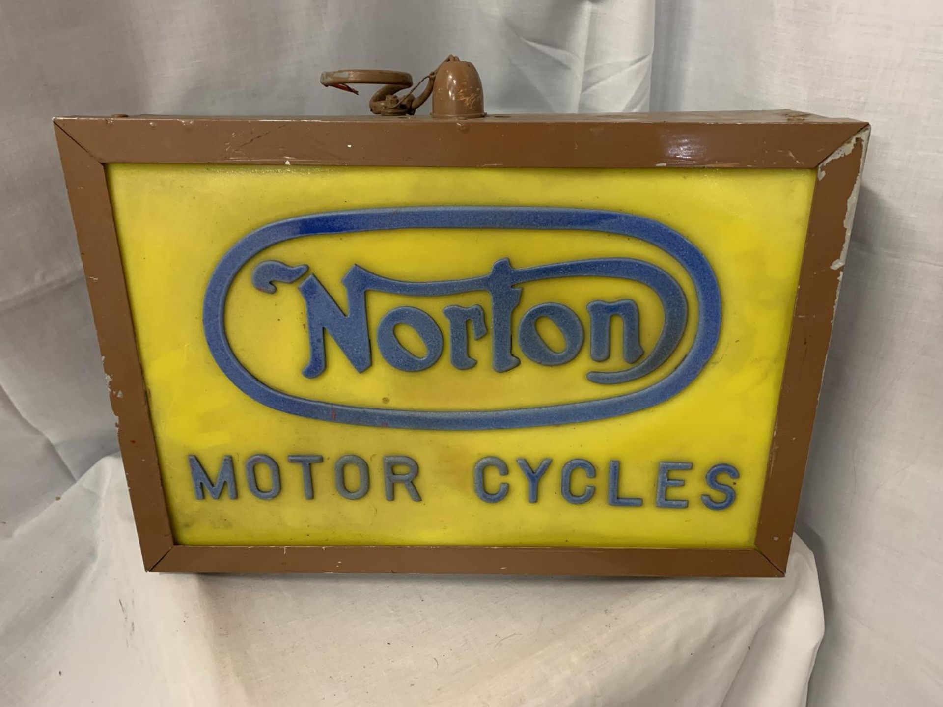 AN ILLUMINATED 'NORTON MOTOR CYCLES' SIGN