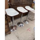 THREE MODERN BAR STOOLS ON CHROME BASES WITH RED AND WHITE SEATS