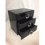 A BLACK GLOSS THREE DRAWER JEWELLERY BOX