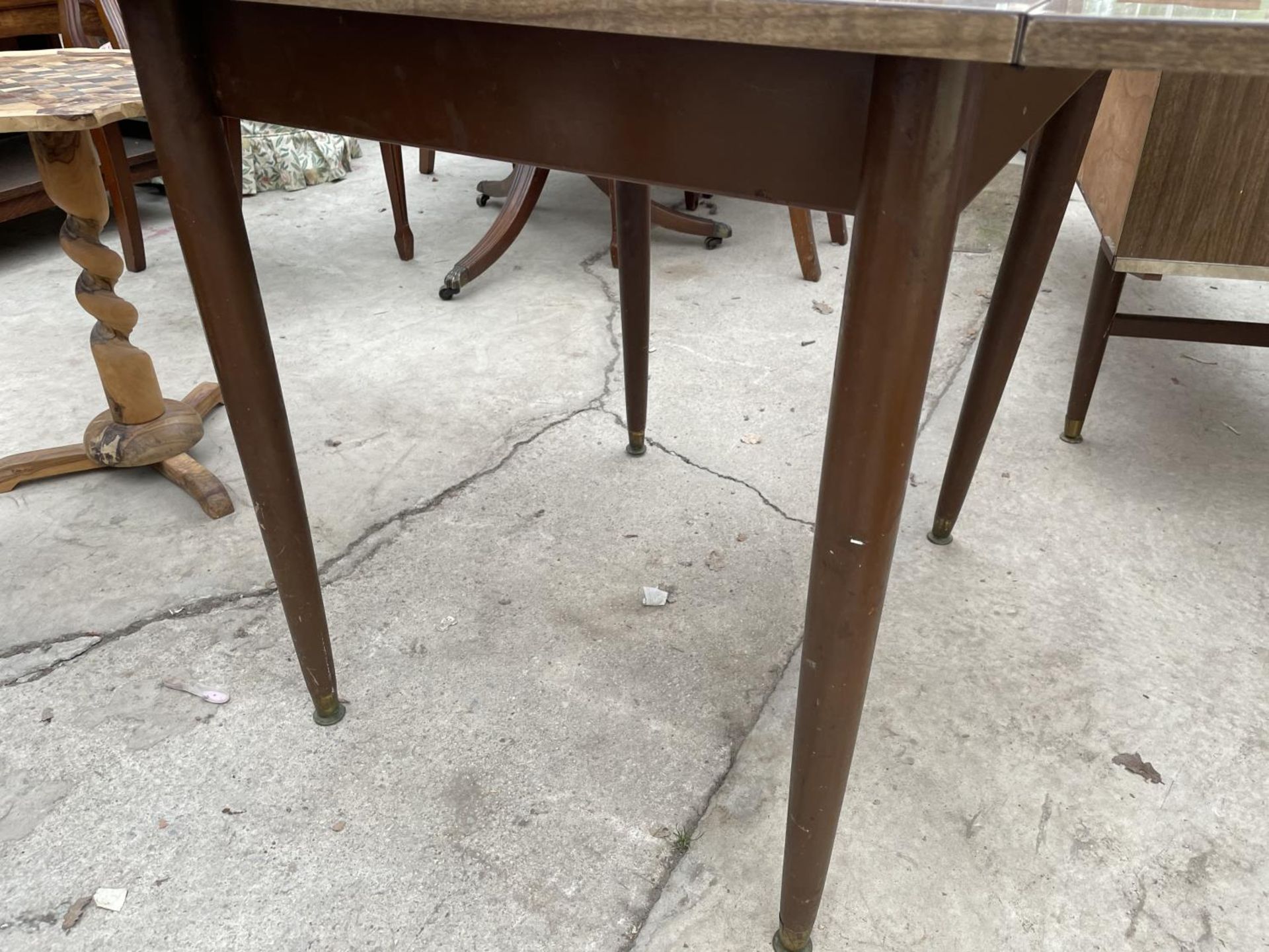 A 1950'S CREAMY WALNUT EFFECT DROP-LEAF DINING TABLE ON TAPERED LEGS - Image 3 of 4