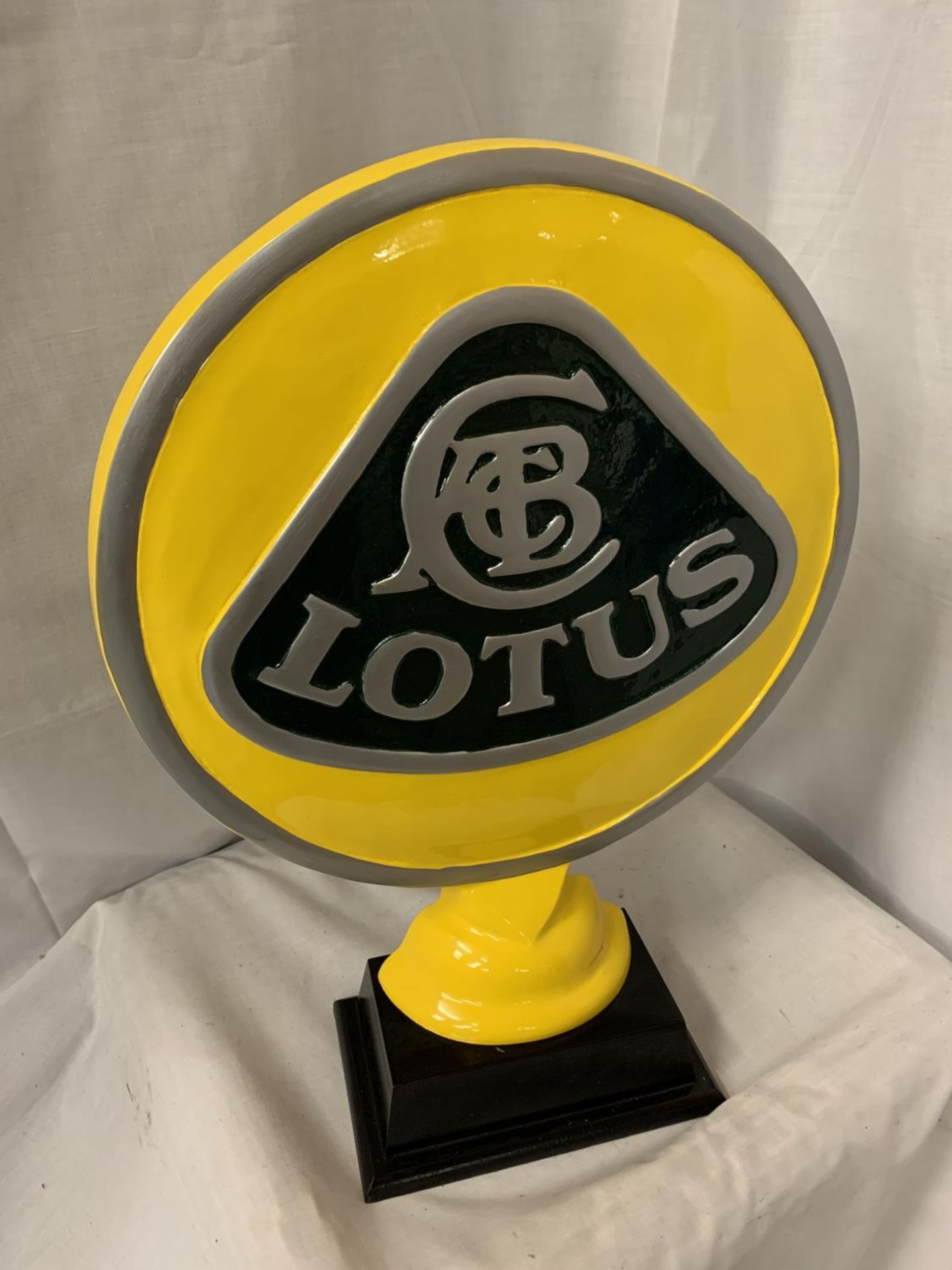 A LARGE CAST LOTUS SIGN ON A WOODEN BASE H:51CM