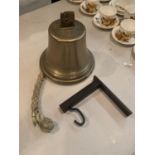 A LARGE BRASS BELLWITH WALL BRACKET