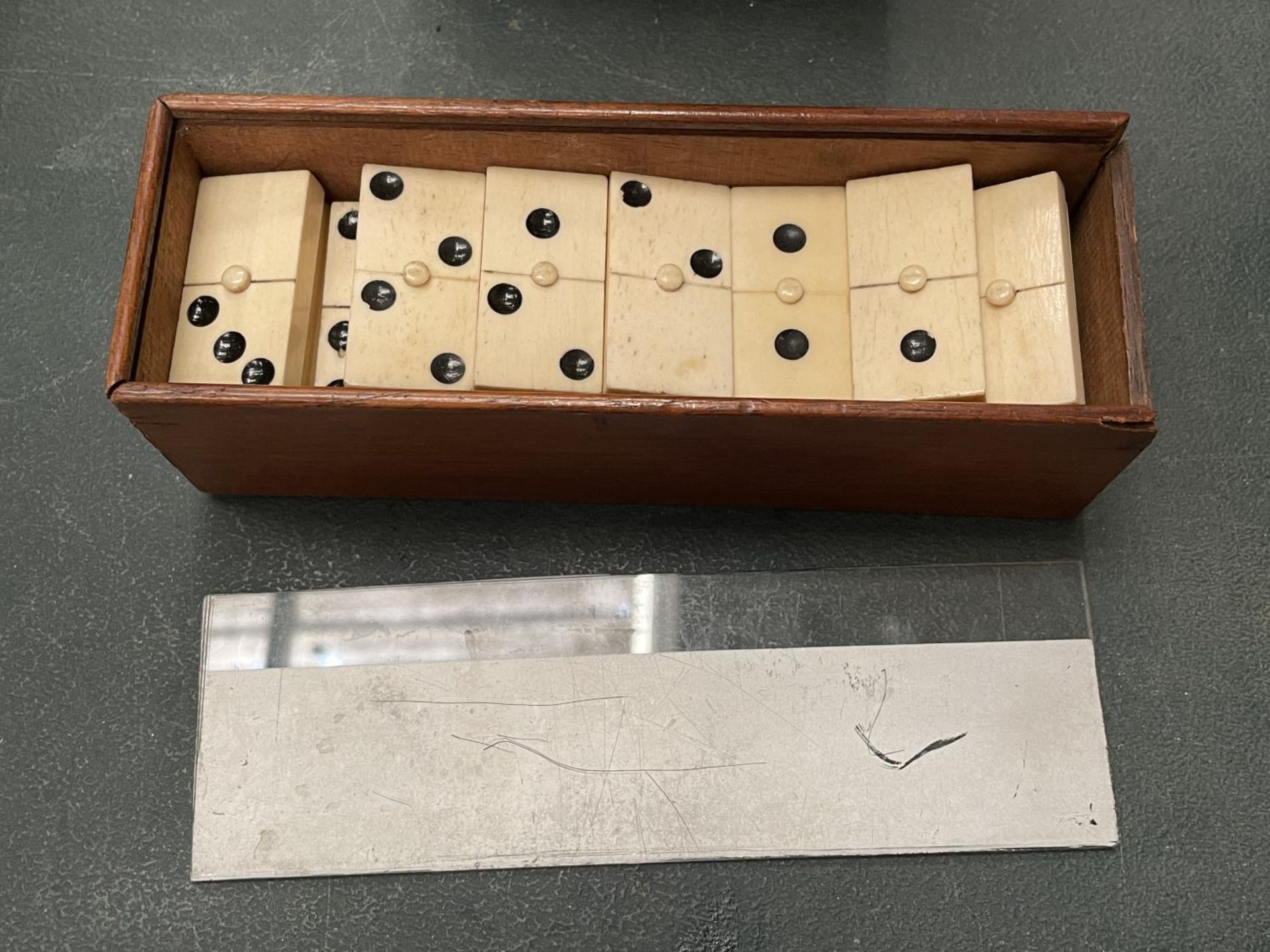 A WOODEN BOXED SET OF BONE DOMINOES