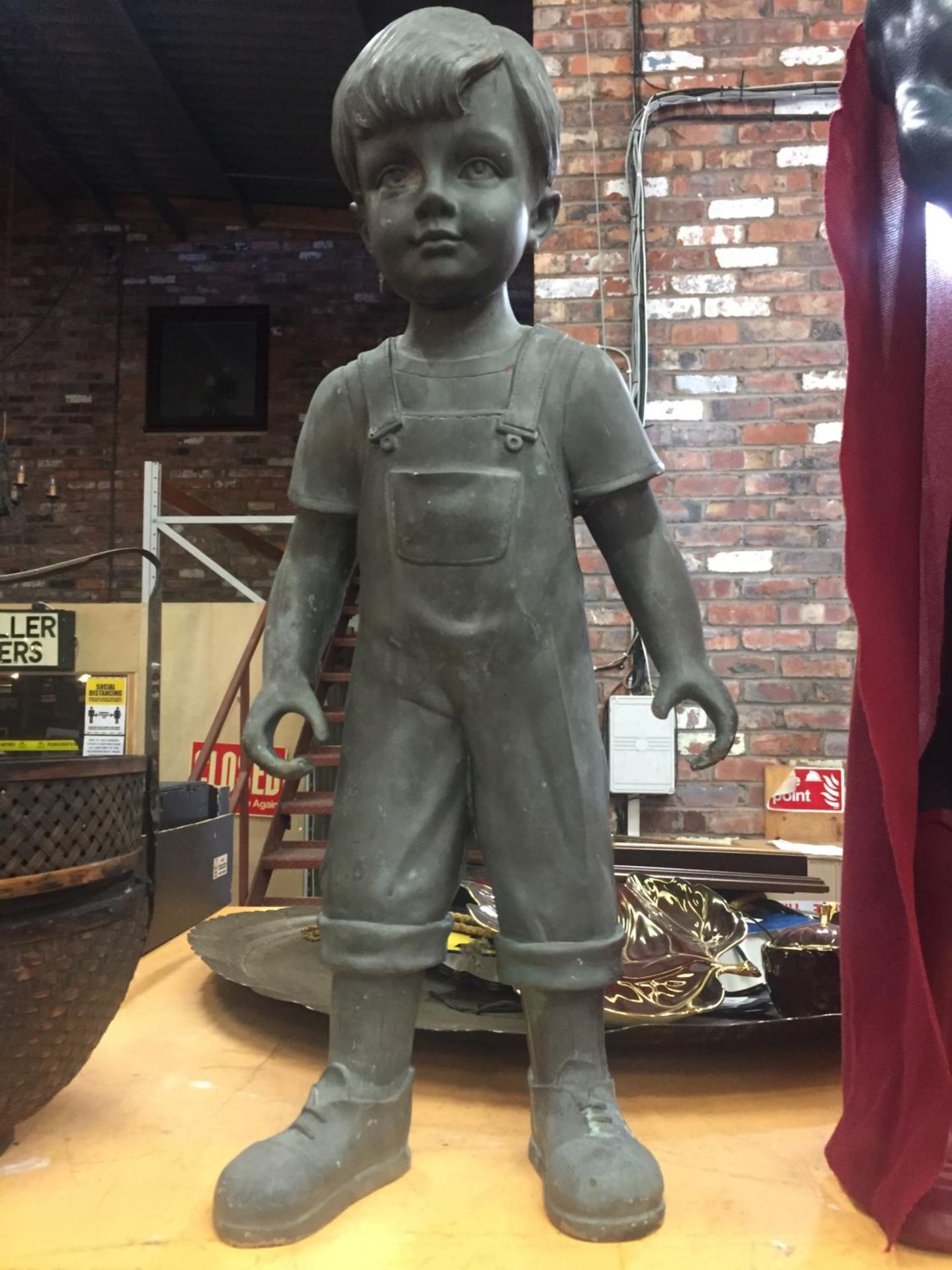 A RESIN MODEL OF A YOUNG BOY IN DUNGAREES (HAND A/F)