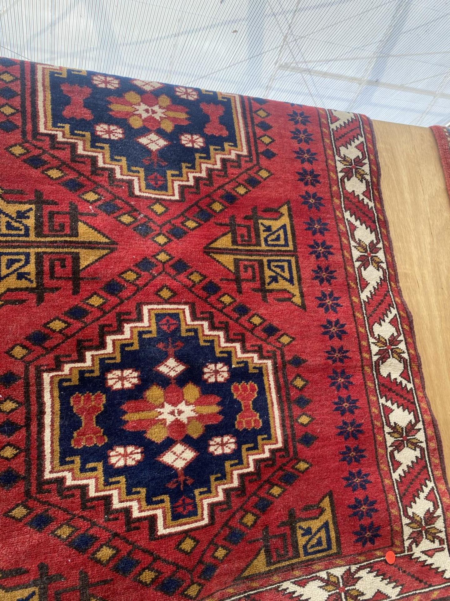A RED PATTERNED RUG - Image 3 of 4