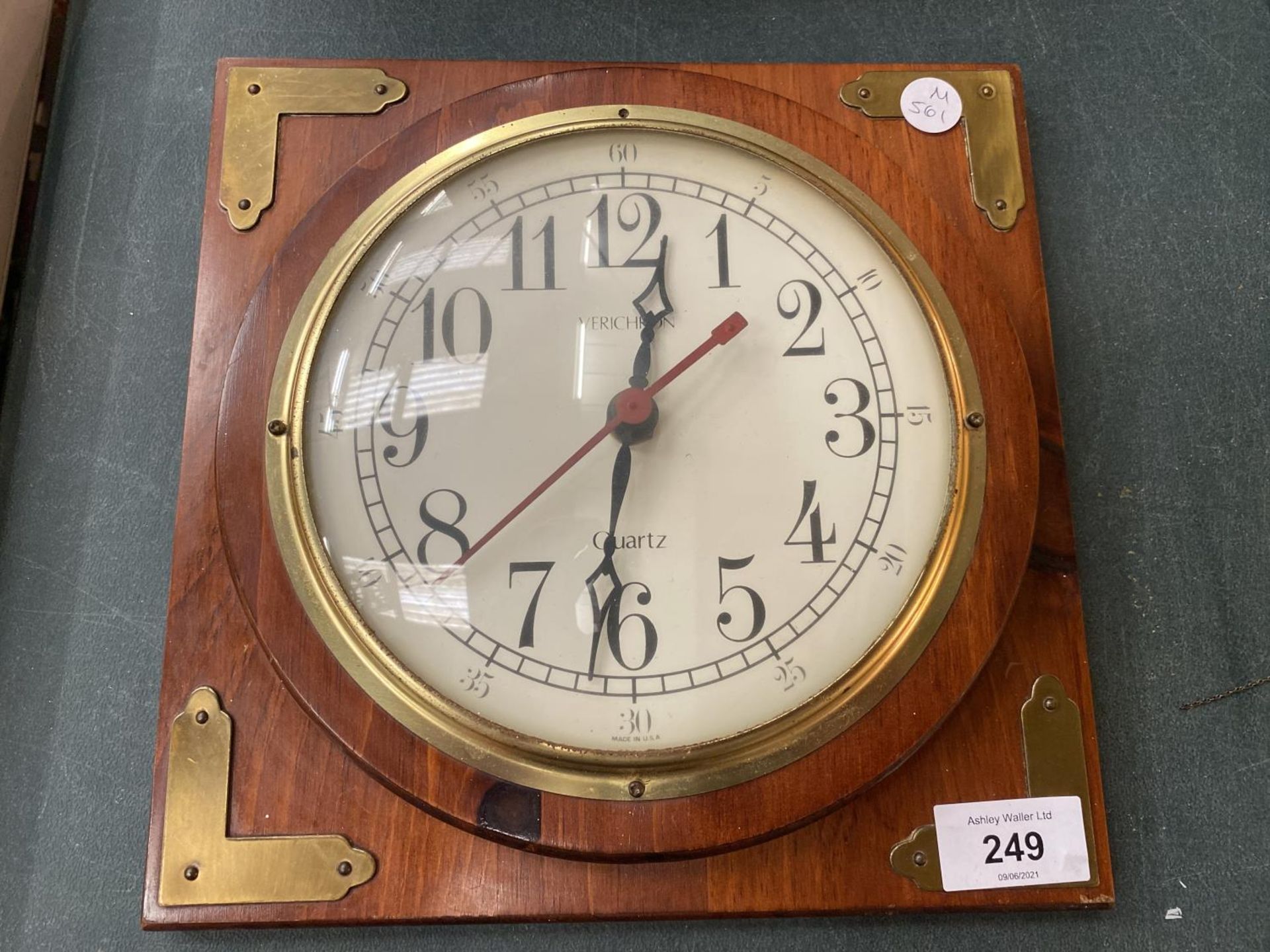 A WOODEN FRAMED WALL CLOCK WITH BRASS CORNERS