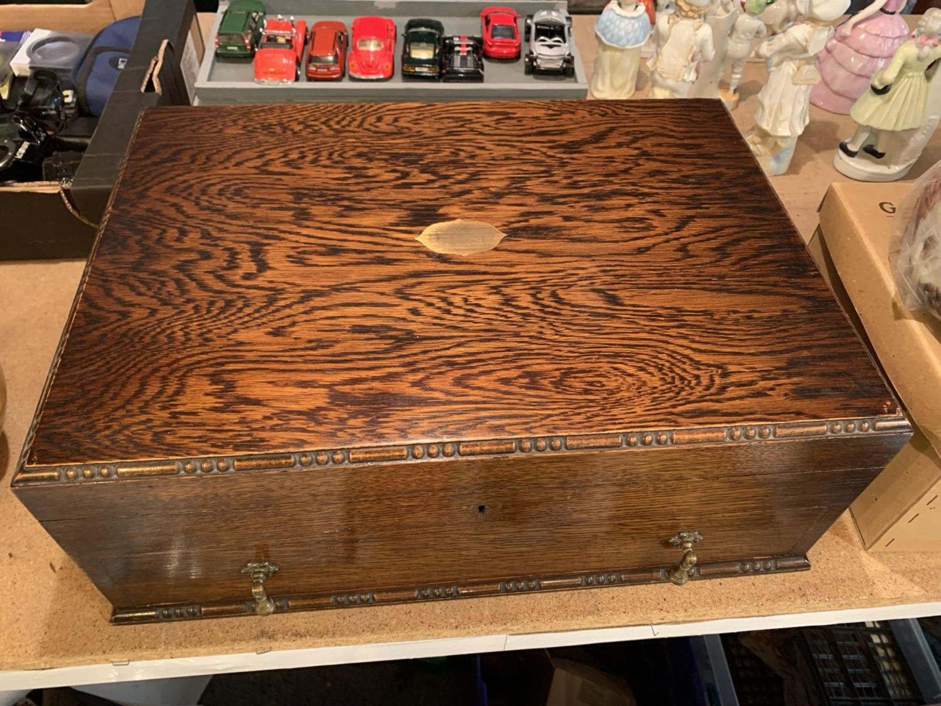 A LARGE OAK CUTLERY DISPLAY BOX WITH BRASS INLAY AND A BLUE FELT INTERIOR