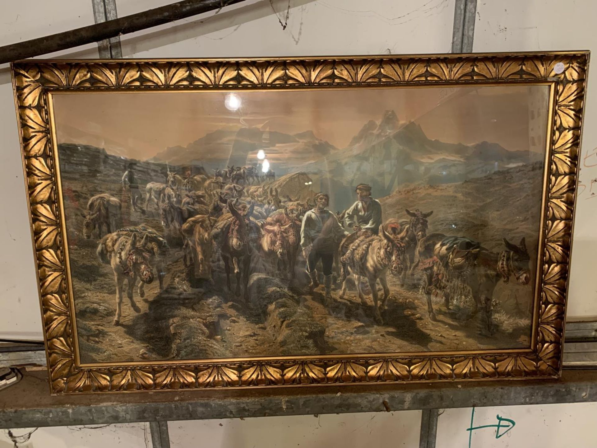 A LARGE GILT FRAMED PICTURE OF DONKEYS BEING HERDED