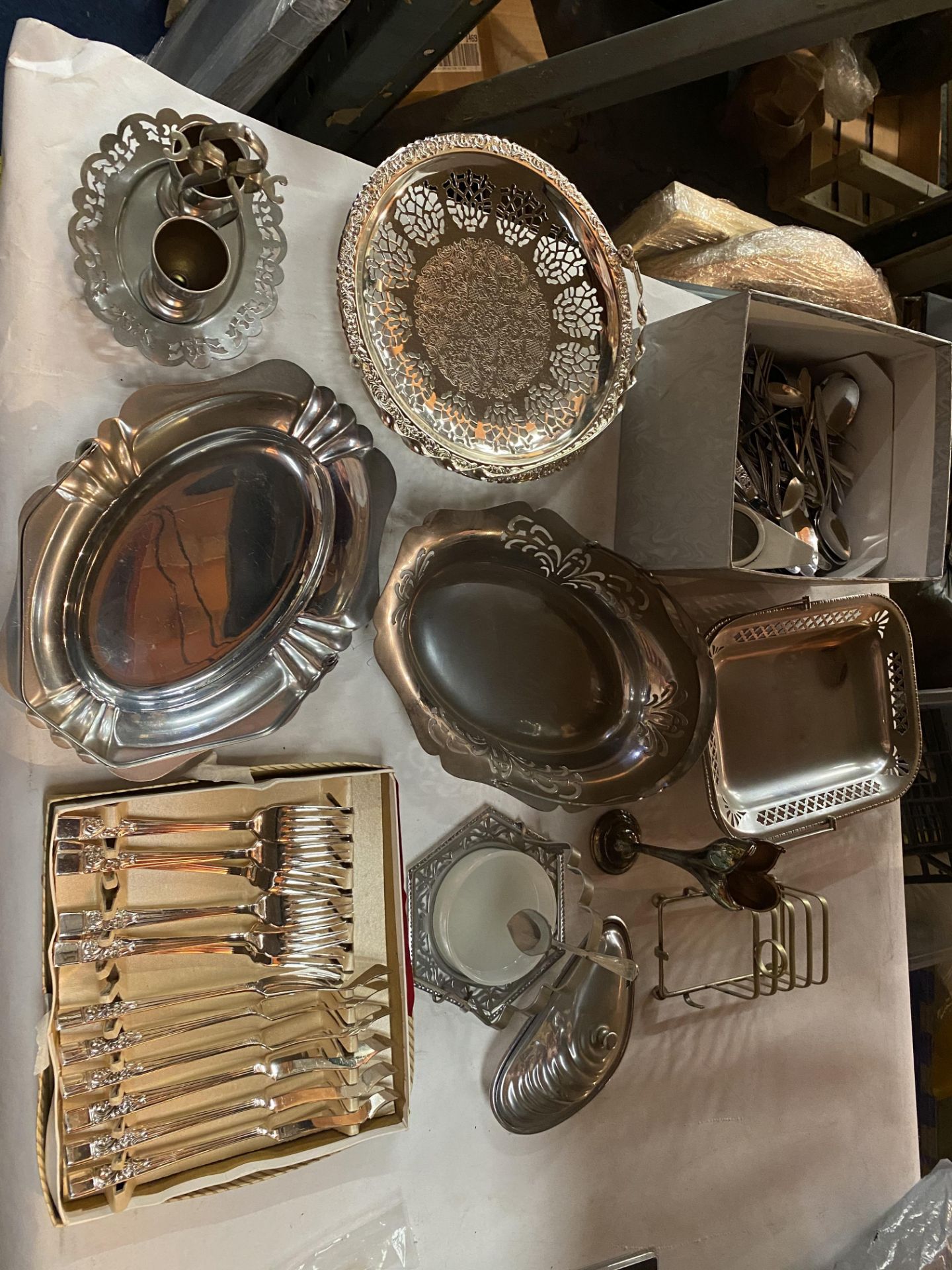 A COLLECTION OF STAINLESS STEEL DECORATIVE PLATES, EGG CUPS ON A TRAY, TOAST RACK , CUTLERY