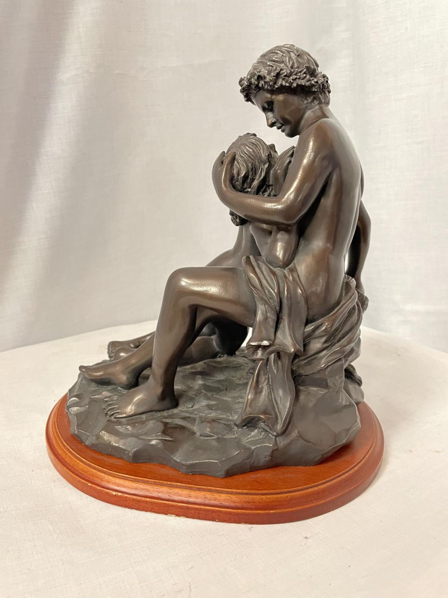 A BRONZE STYLE ORNAMENT OF AN EMBRACING COUPLE ON WOODEN STAND, HEIGHT 27CM - Image 3 of 4