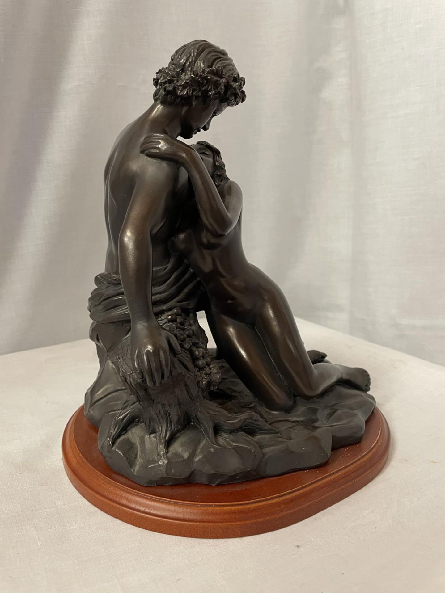 A BRONZE STYLE ORNAMENT OF AN EMBRACING COUPLE ON WOODEN STAND, HEIGHT 27CM - Image 4 of 4