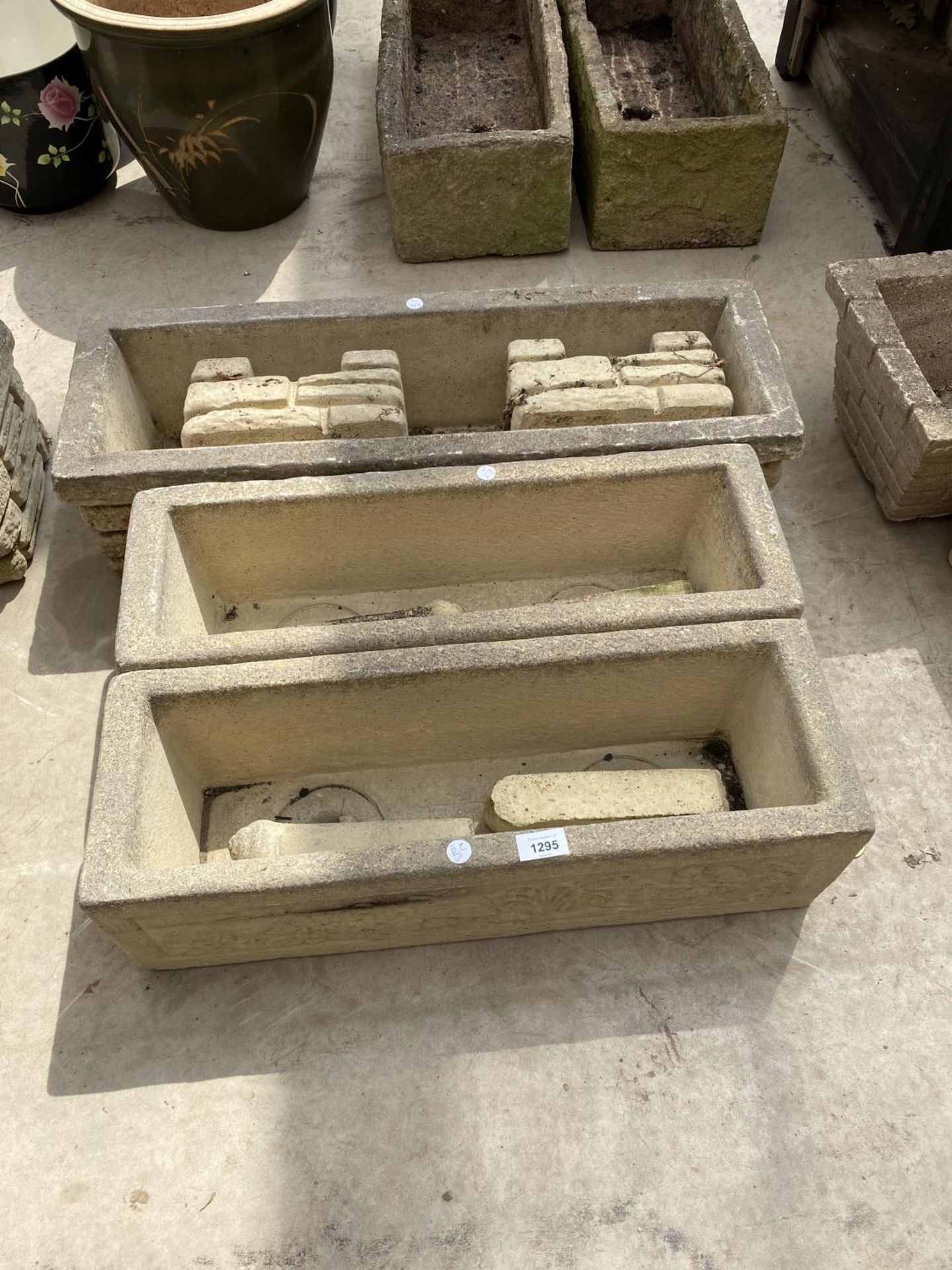 A GROUP OF THREE DECORATIVE STONE EFFECT PLANTERS