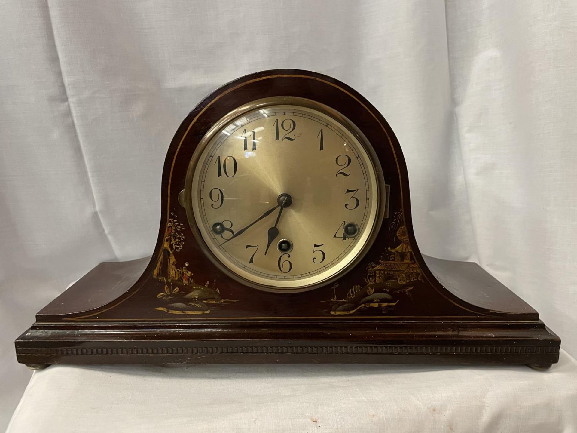 A MAHOGANY MANTLE CLOCK WITH AN ORIENTAL PATTERN 45CM LENGTH