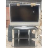 A PANASONIC 26" TELEVISION AND A MODERN GLASS TV STAND