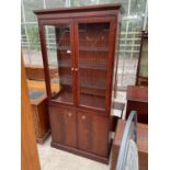 A STAGE TWO DOOR GLAZED BOOKCASE ON BASE, 36" WIDE