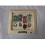 FOUR MASONIC MEDALS IN A FRAME