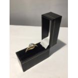 A 9 CARAT GOLD RING WITH A CLEAR STONE SOLITAIRE AND CLEAR STONES ON THE SHOULDERS WITH PRESENTATION