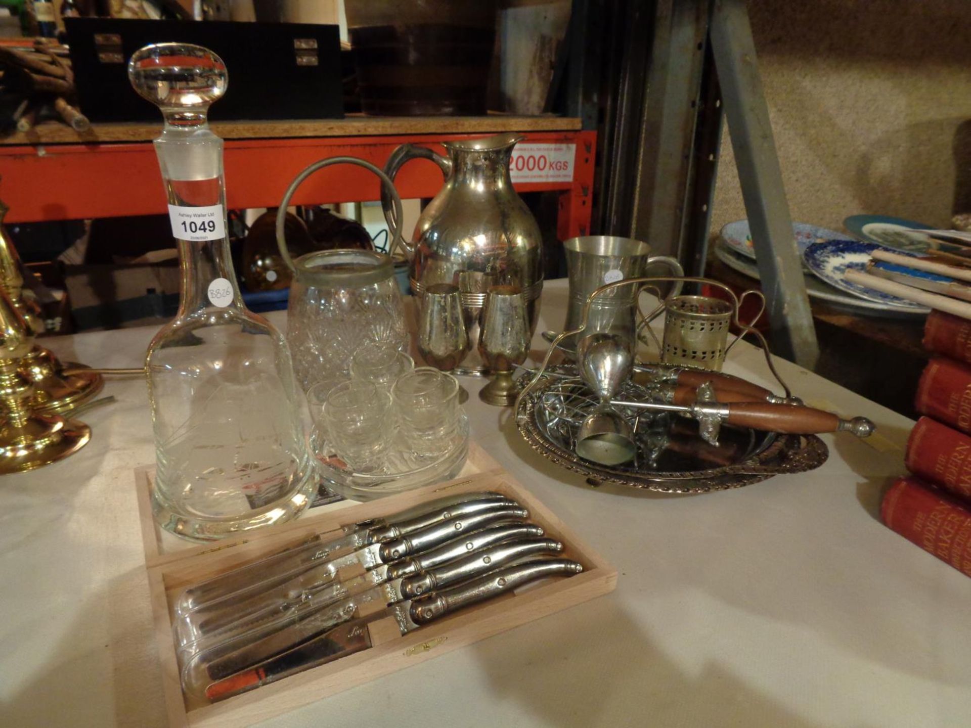 AN ASSORTMENT OF WHITE METAL ITEMS TO INCLUDE A CAKE STAND AND A SHIP THEMED DECANTER
