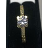 A 9 CARAT GOLD RING WITH CENTRE CLEAR STONE AND CHIPS TO SHOULDERS