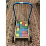 A VINTAGE WOODEN TRI-ANG BABY WALKER TO INCLUDE WOODEN BLOCKS