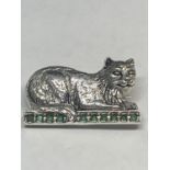 A MARKED SILVER CAT BROOCH LYING ON A LINE OF GREEN STONES
