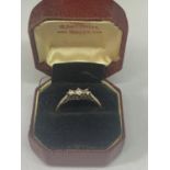 AN 18 CARAT GOLD RING WITH THREE IN LINE STONES POSSIBLY DIAMONDS SIZE O WITH A PRESENTATION BOX