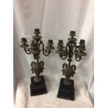 A VINTAGE PAIR OF ORNATE METAL FIVE CANDLE CANDLESTICKS ON PLINTHS