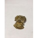 A SILVER GILT PENDANT IN THE FORM OF A DOG WITH GLASS EYES