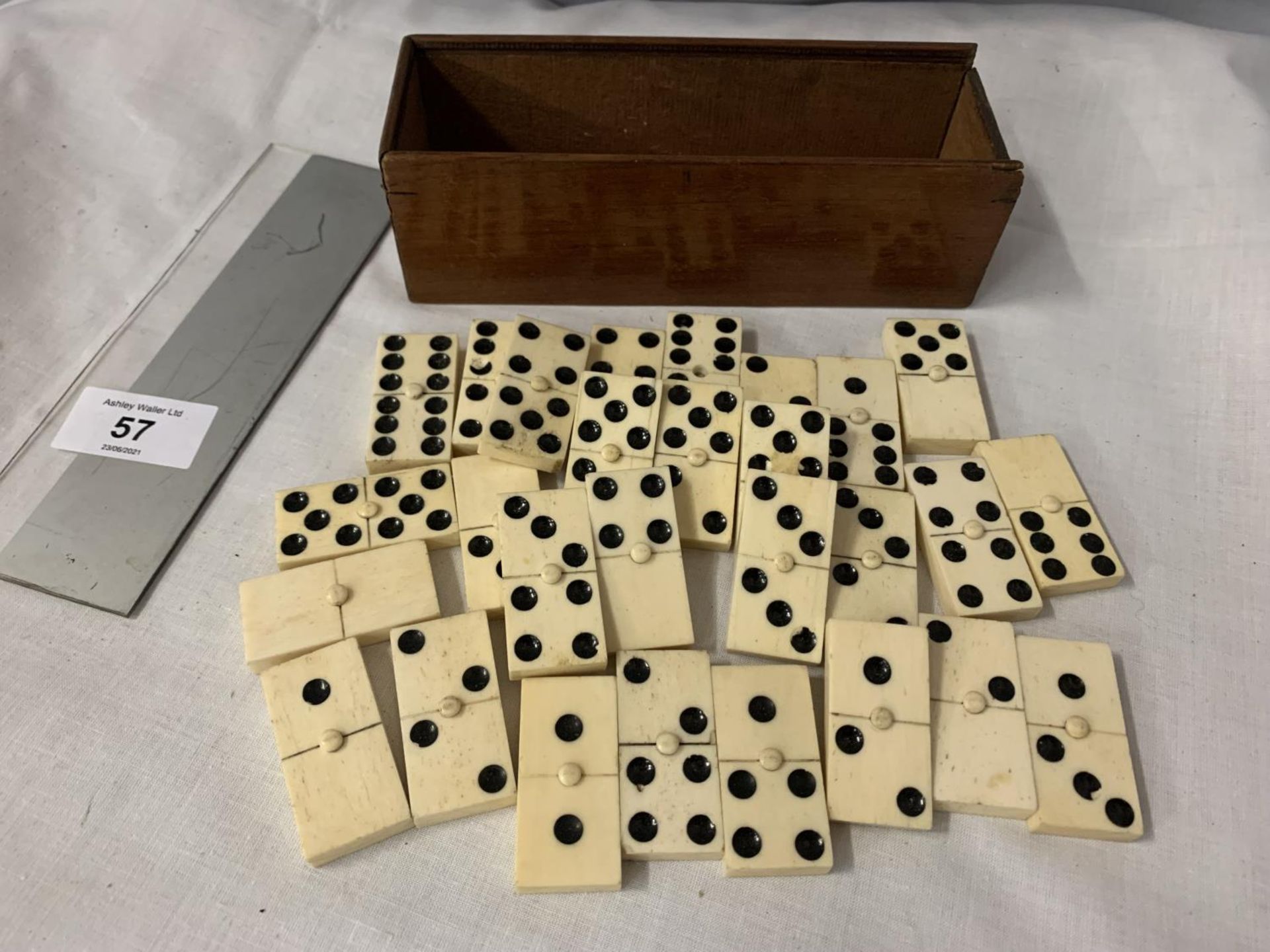 A WOODEN BOXED SET OF BONE DOMINOES