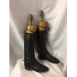 A PAIR OF LEATHER RIDING BOOTS WITH VINTAGE WOODEN BOOT SUPPORTS
