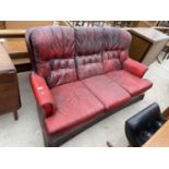 AN OXBLOOD BUTTON BACK THREE SEATER SETTEE