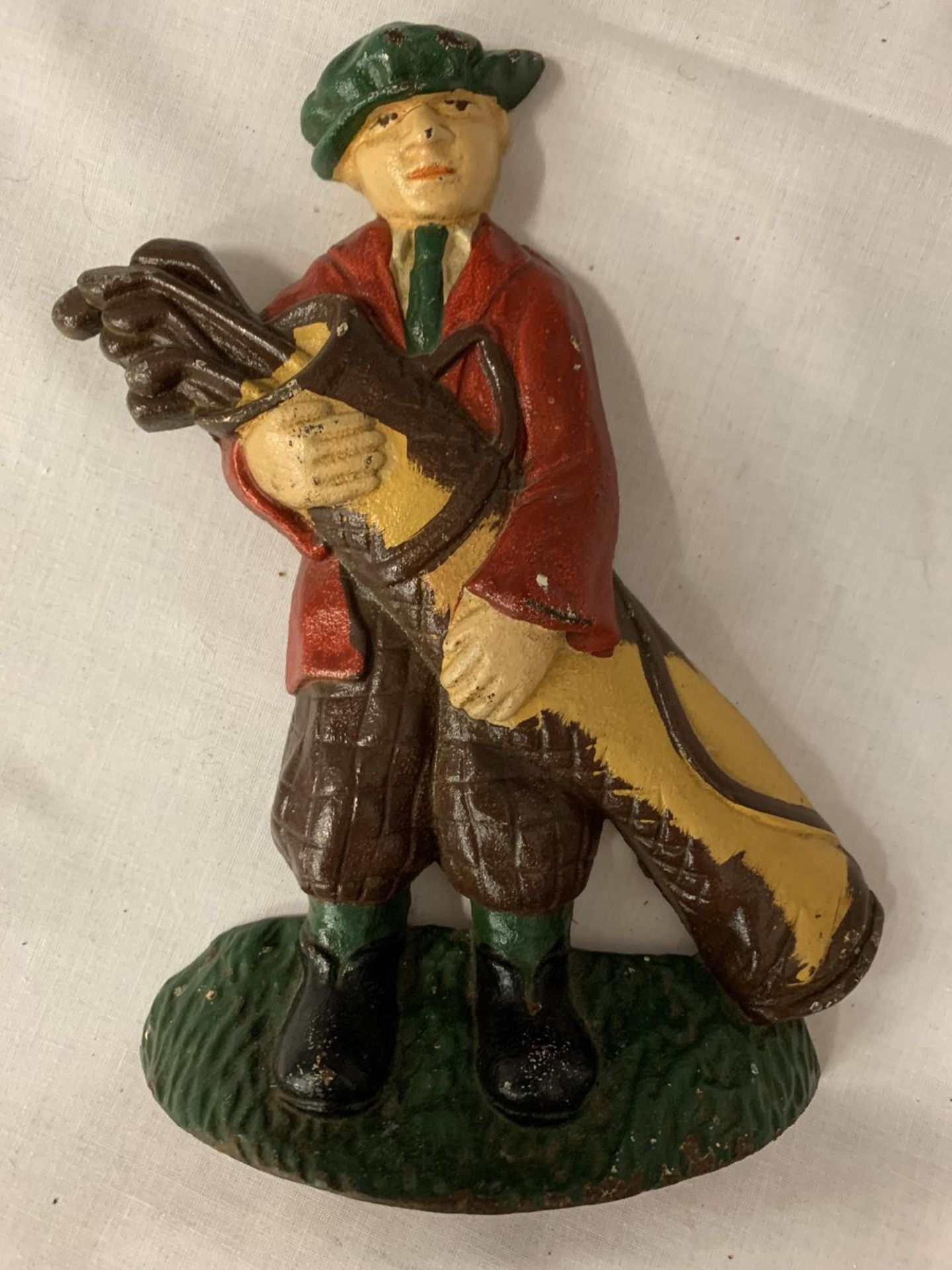 A PAINTED CAST IRON DOOR STOP IN THE SHAPE OF A GOLFER CARRYING HIS CLUBS