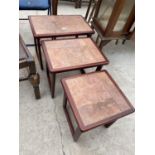 A RETRO TEAK NEST OF THREE TABLES WITH INSET TILED TOPS