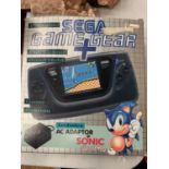 A BOXED PORTABLE HAND HELD SEGA GAME + GEAR (INCLUDES ADAPTER)