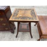 AN EARLY 20TH CENTURY CARVED OAK OCCASIONAL TABLE WITH LOWER SHELF