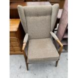 A 20TH CENTURY BEECH FRAMED FIRESIDE CHAIR