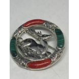 A MARKED SILVER BROOCH WITH RED AND GREEN STONES SURROUNDING A CENTRAL STAG DESIGN