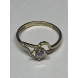 A 9 CARAT GOLD TWIST STYLE RING WITH CENTRE CLEAR STONE AND CHIP SHOULDERS