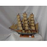 A WOODEN MODEL OF THE SAILING SHIP FLYING CLOUD ON A PLINTH L:51CM