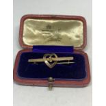 A 9 CARAT GOLD PIN BADGE WITH HEART AND FLOWER DESIGN IN A PRESENTATION BOX