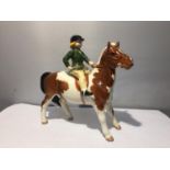 A BESWICK SKEWBALD PONY WITH GIRL RIDER